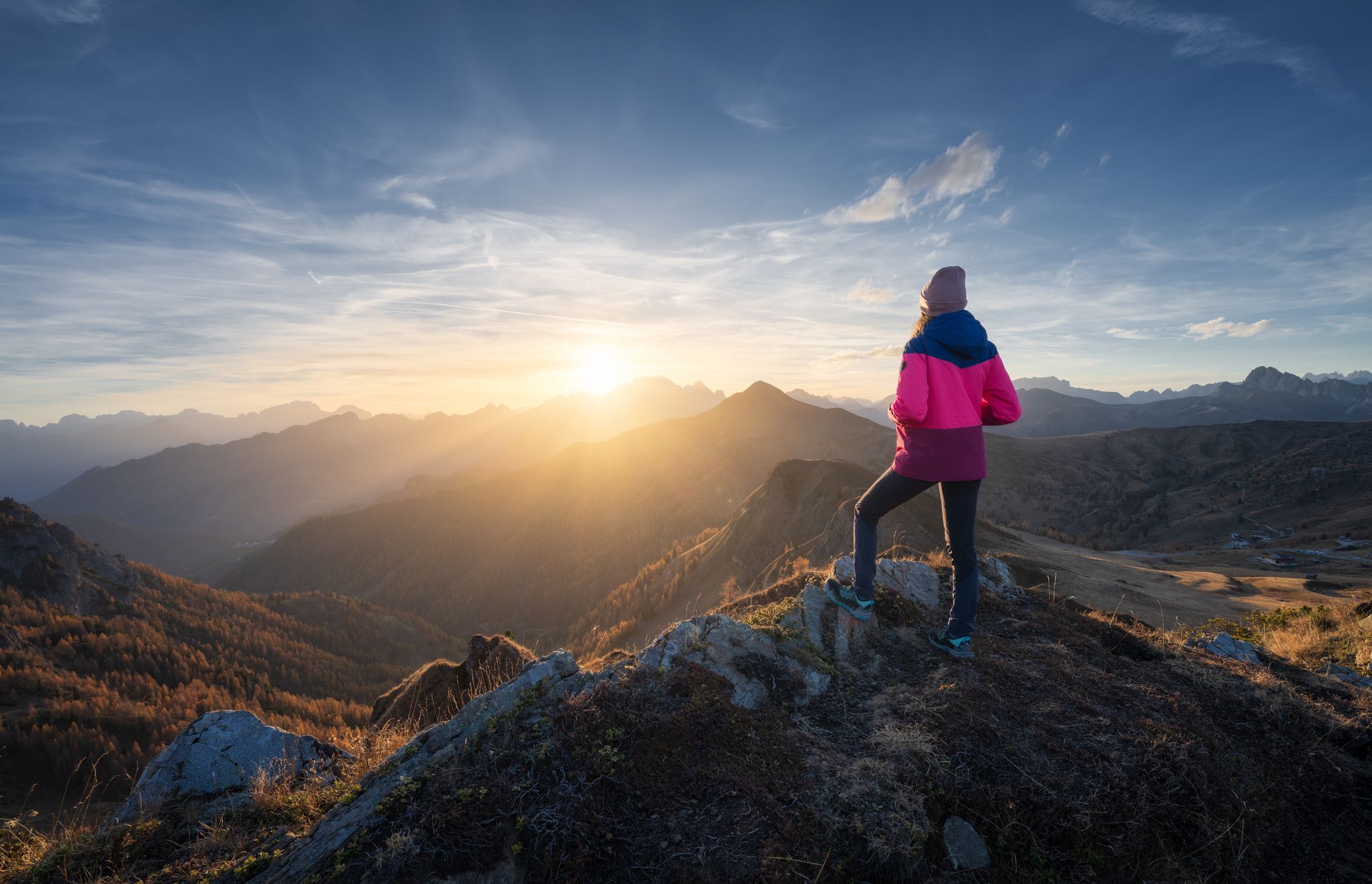Woman on a journey towards a new dawn over beautiful mountains